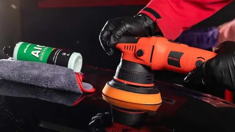 Professional performing multi-stage paint correction with polishing machine